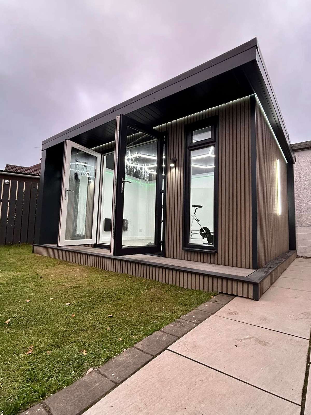 Dark clad cabin with a glazed front, photographed in daylight
