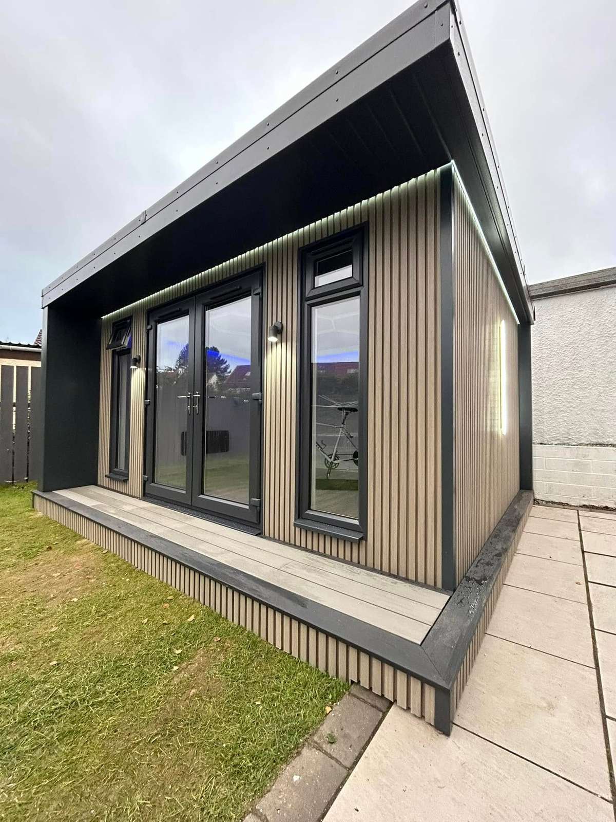 Dark clad cabin with patio doors, in daylight