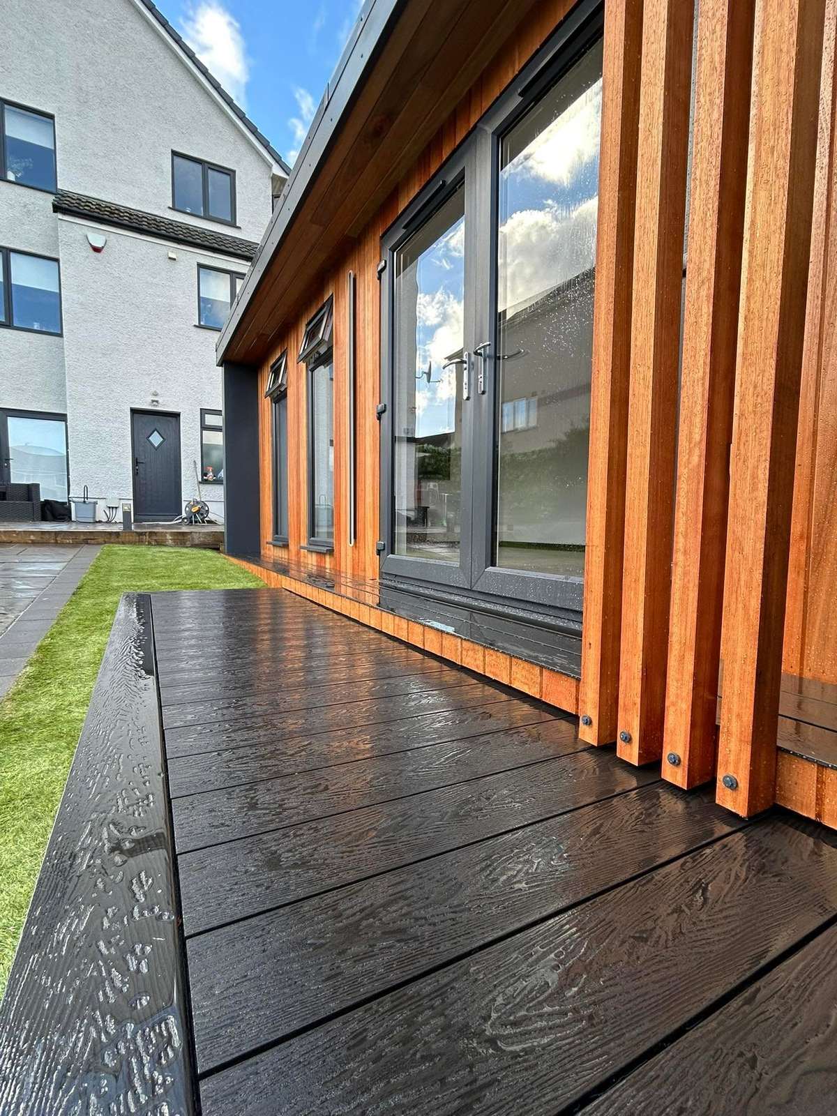 Timber clad cabin with a timber deck, in daylight