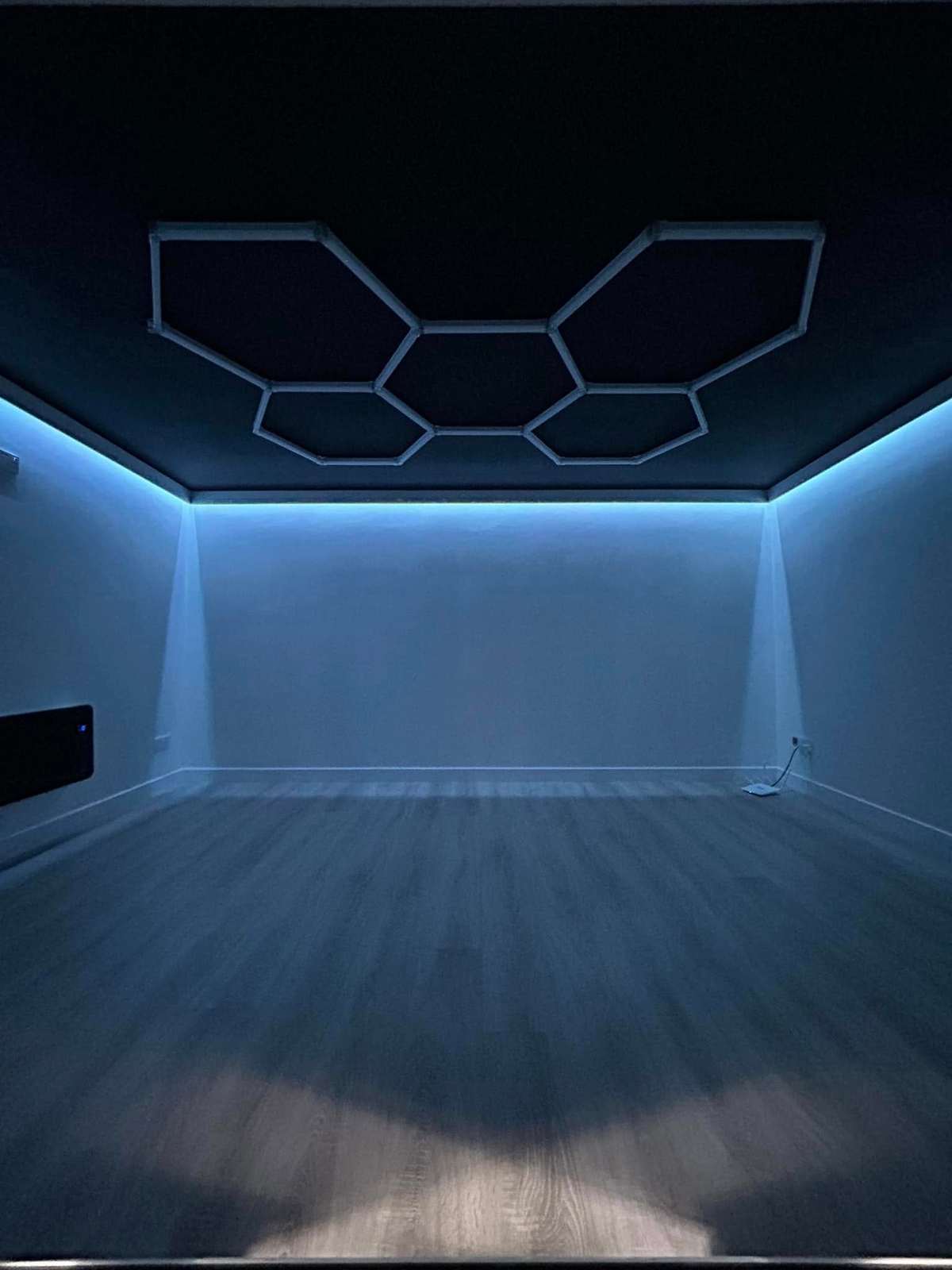 Empty room with hexagon lights set into the ceiling